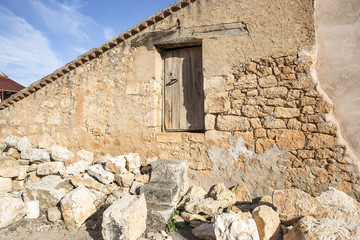 a rustic country house made of stones with a wooden door