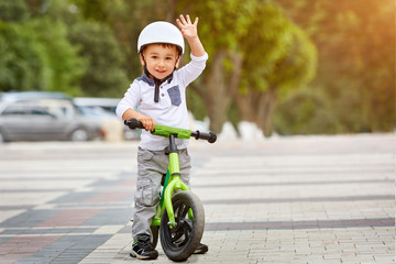 Happy boy in white helmet ride his first bike