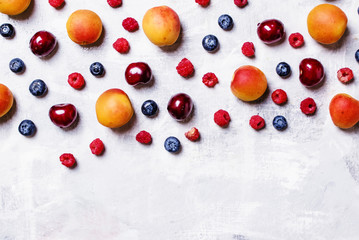 Naklejka na ściany i meble Food background, apricots, blueberries, raspberry and sweet cherry, top view