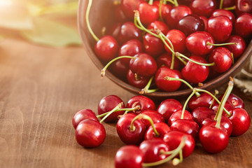 Cherries on wooden table with water drops