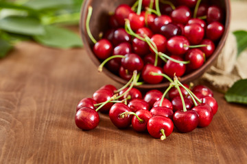 Cherries on wooden table with water drops