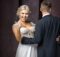 bride rejoices in his good fortune next to the groom in the Studio