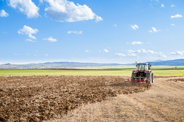 Obraz premium agricultural tractor in the foreground with blue sky background.
