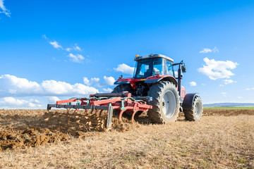 agricultural tractor in the foreground with blue sky background.