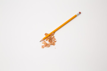 yellow pencil sharpened with shavings on white background