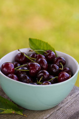 cherries on a turquoise wooden surface