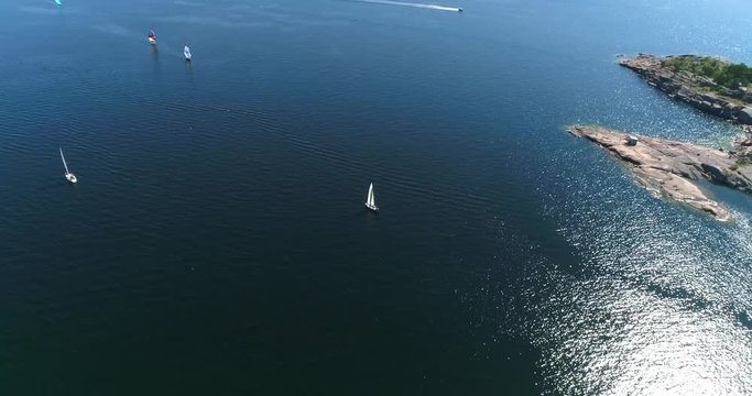 Yellow sailboat, Cinema 4k aerial view following a white sailboat on the baltic sea and towards Hanko city, on hango regatta day, in the finnish archipelago