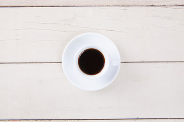 Top view of empty white cup coffee with black coffee put on white wood table with space for copy.