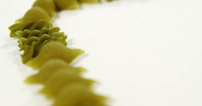 Various fusilli and conchiglie pasta on white background
