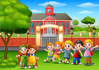 Obraz na płótnie Canvas Happy school children standing in front of school building