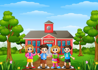 Happy school children standing in front of school building