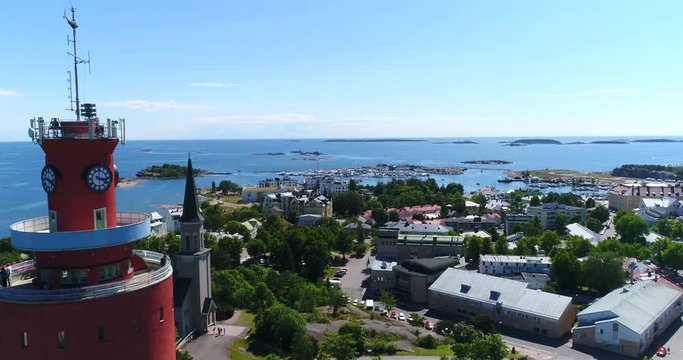 Hanko, Cinema 4k aerial view slowly bypassing the water tower and the church, on Hango regatta day, in Finland