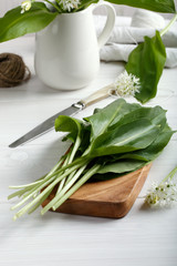 Wild garlic on white wooden table.