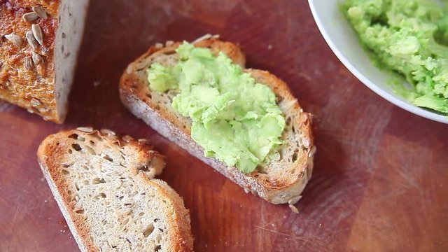 Making avocado toast with bread studded with sunflower and other seeds