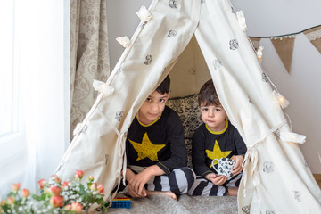 Brothers playing in a teepee