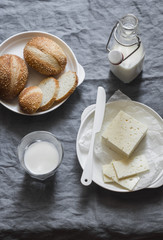 Simple country snake - bread, sheep's cheese and milk on a gray background, top view
