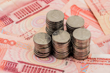 piles of coins on chinese banknotes