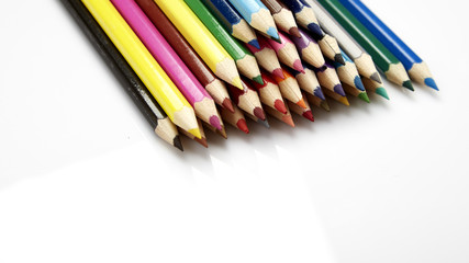 Many different colored pencils on white background