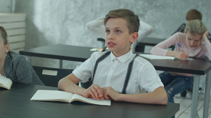 Bored school boy day dreaming during a class