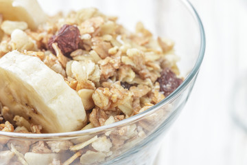 Homemade granola with banana, nuts and raisins closeup. Selective focus