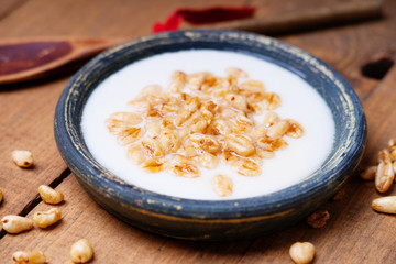 Dish of cereal with milk and wooden spoon 