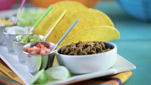 Fresh beef tacos in hard yellow corn taco shell with sour cream and shredded cheese