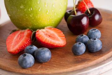 Fresh fruits on a wooden cutting board 