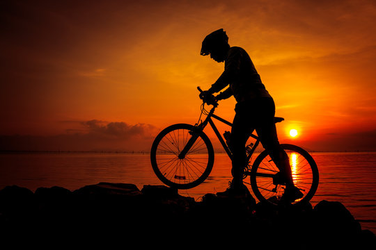 Silhouette of bicyclist enjoying the view at seaside. Outdoors.