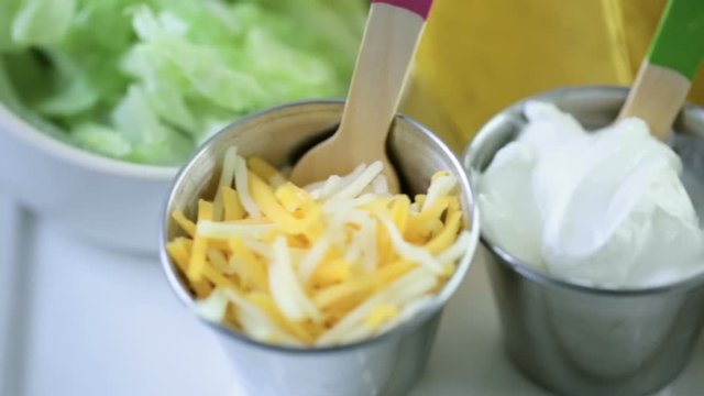 Fresh beef tacos in hard yellow corn taco shell with sour cream and shredded cheese