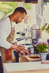 Fototapeta premium Black bearded coffee seller pouring coffee.