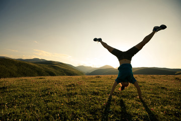  woman doing a handstand in a meadow