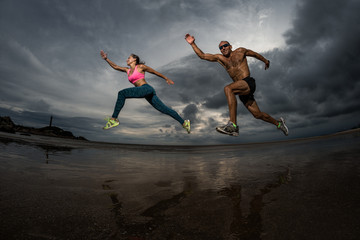 Fototapeta na wymiar Sport couple runnig on the beach