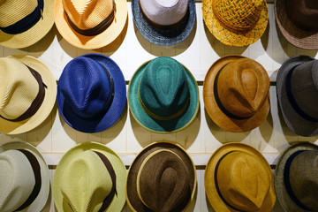 Display of colorful summer straw hats on a wall