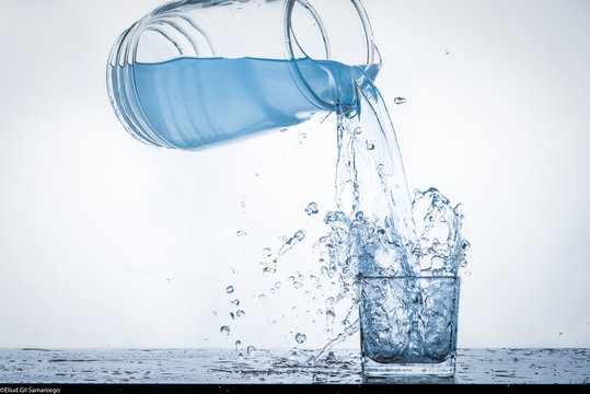 jarra de agua llenando vaso con splash