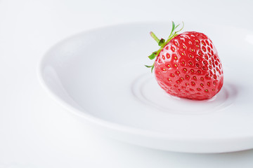 Fresh strawberry on white saucer isolated on white background. Summer breakfast.