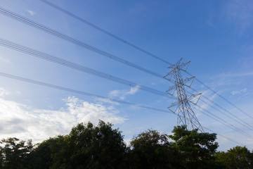 High voltage transmission towers through the farmland, wide shot