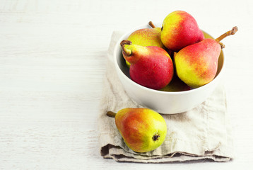 Red pears in a white plate top view.