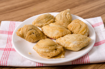 Curry puff snacks on white dish with wooden background.