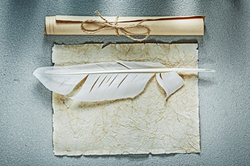 Vintage paper scrolls feather on grey background top view