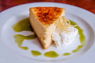 Cheesecake on white plate with whipped cream