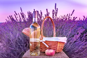 Photo sur Plexiglas Pique-nique Bouteille de vin blanc et panier pique-nique dans un champ de lavande