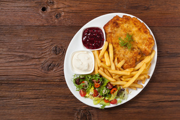 Chicken schnitzel, served with fries and salad.
