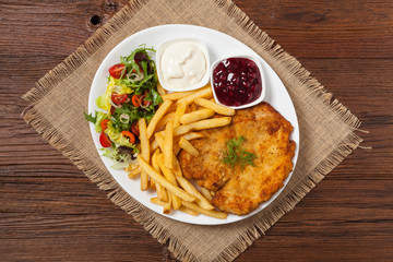 Chicken schnitzel, served with fries and salad.