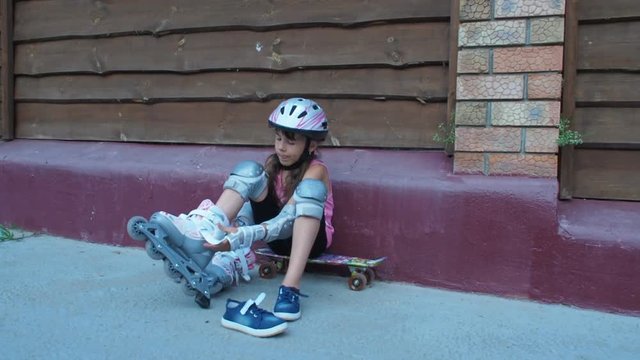 Little girl dresses roller skates. Child in protection for commercials.