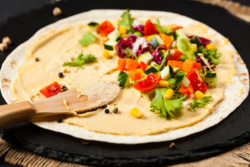 Tortilla with vegetables and hummus with chickpeas.