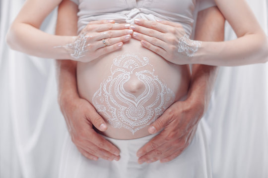 Pregnant Belly Closeup With White Henna Painting In Boho Style.