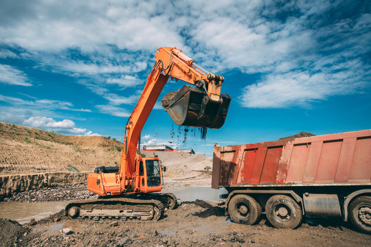 excavator, bulldozer loading dumper truck during highway construction site