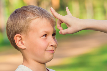 Blond boy waiting for a flick of finger in the forehead