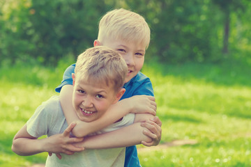 Boy during the game strangles a friend in the park