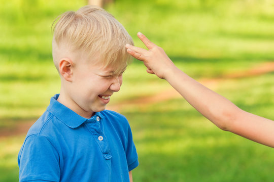 Boy In Blue T-shirt Waiting For A Flick Of Finger In The Forehead